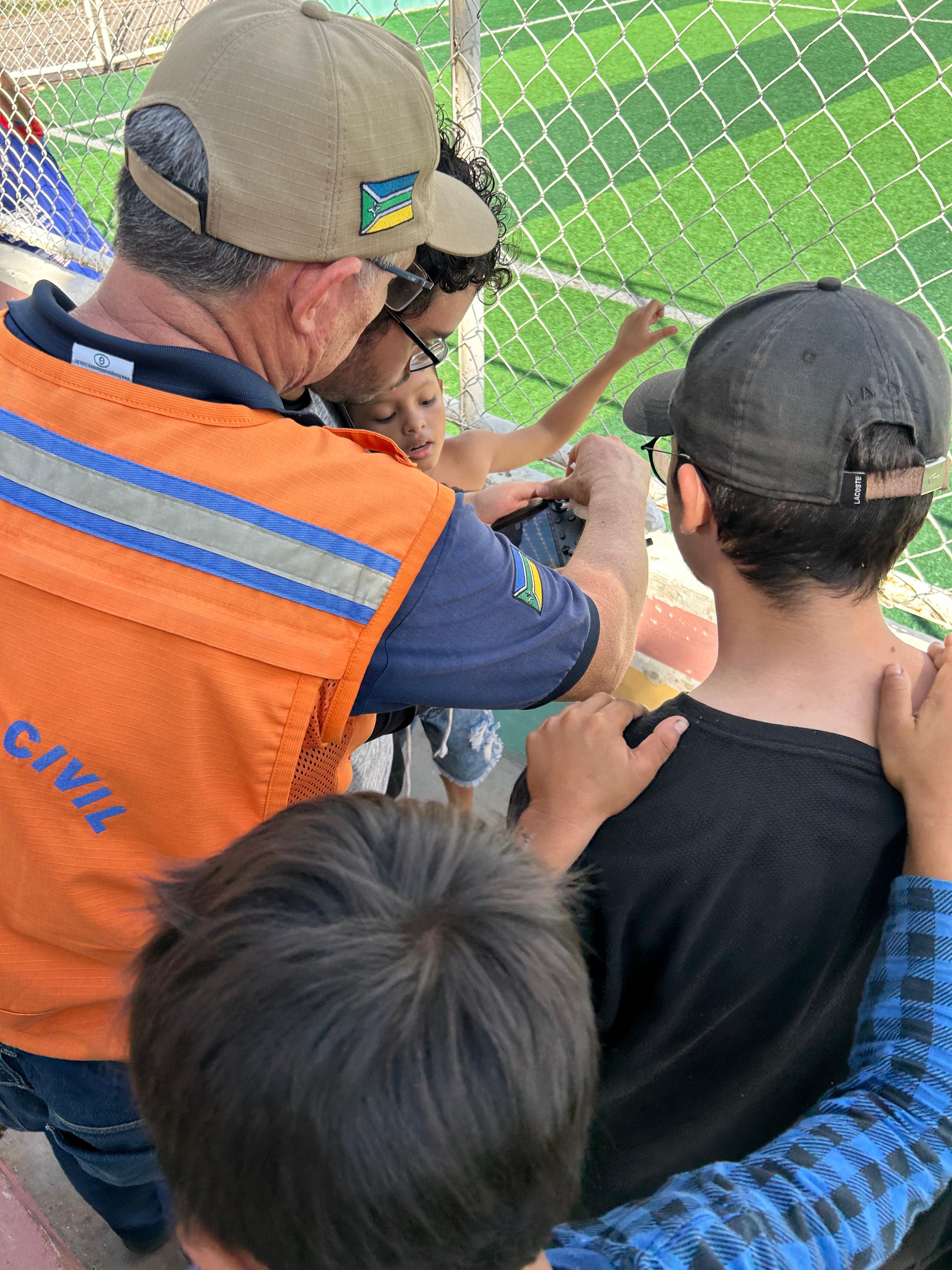 Imagem 04: (Campo): Subtenente Marlon orienta alunos durante atividade prática no bairro das Pedrinhas, área monitorada por riscos de movimentos de massa.